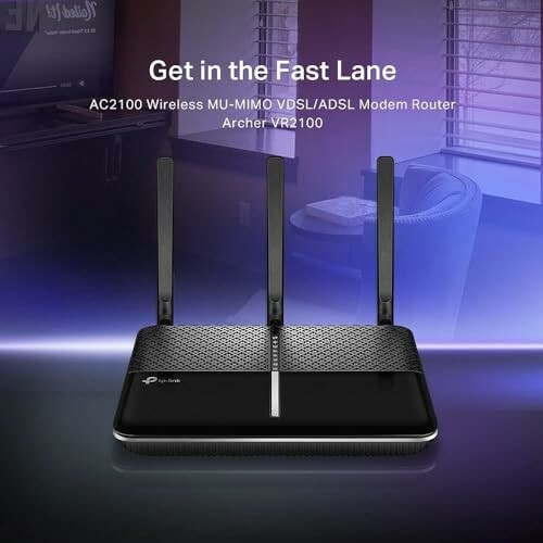 TP-Link Archer VR2100 modem router with three antennas on a table.